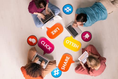 birds eye view of four young friends using social media