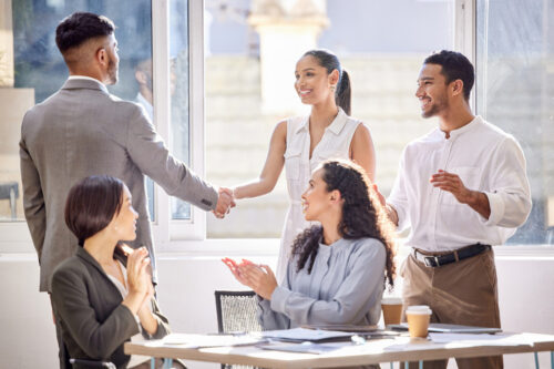 Employees and manager shaking hands