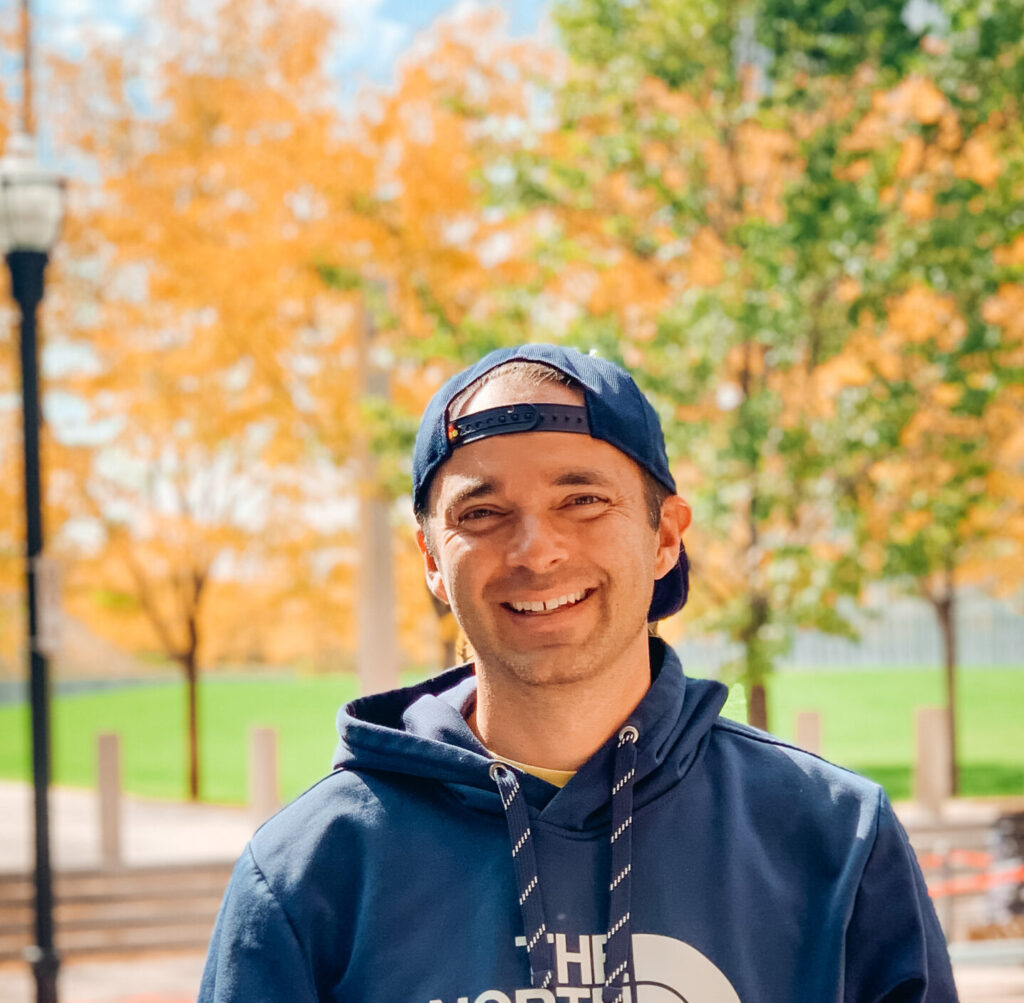 Smiling man in a hoodie with a backwards hat