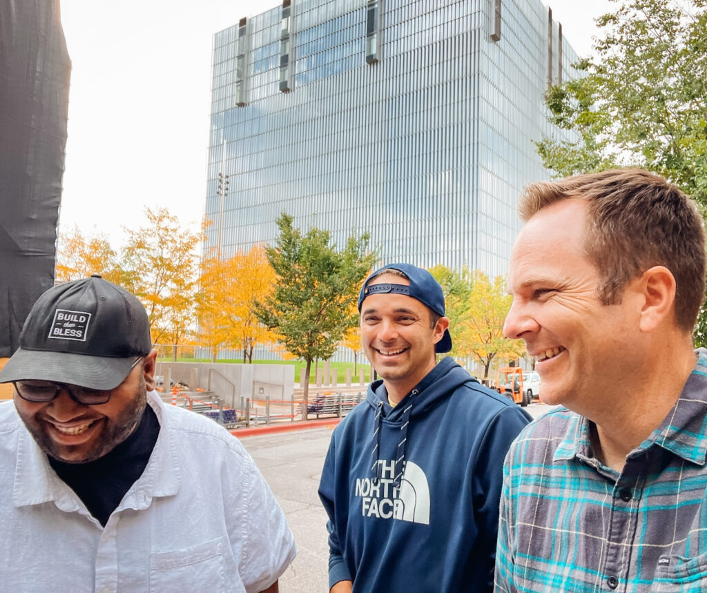 Three men smiling while walking