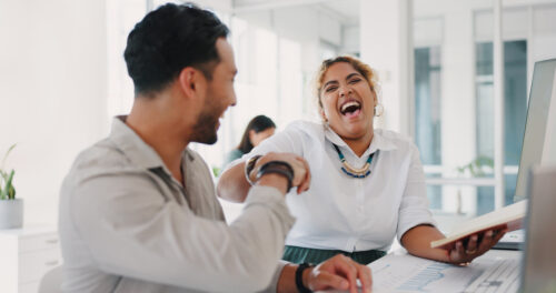 two employees laughing and having fun at work