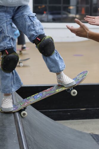 a kid balances a skateboard on the edge of a ramp