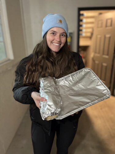 young woman holding lasagna